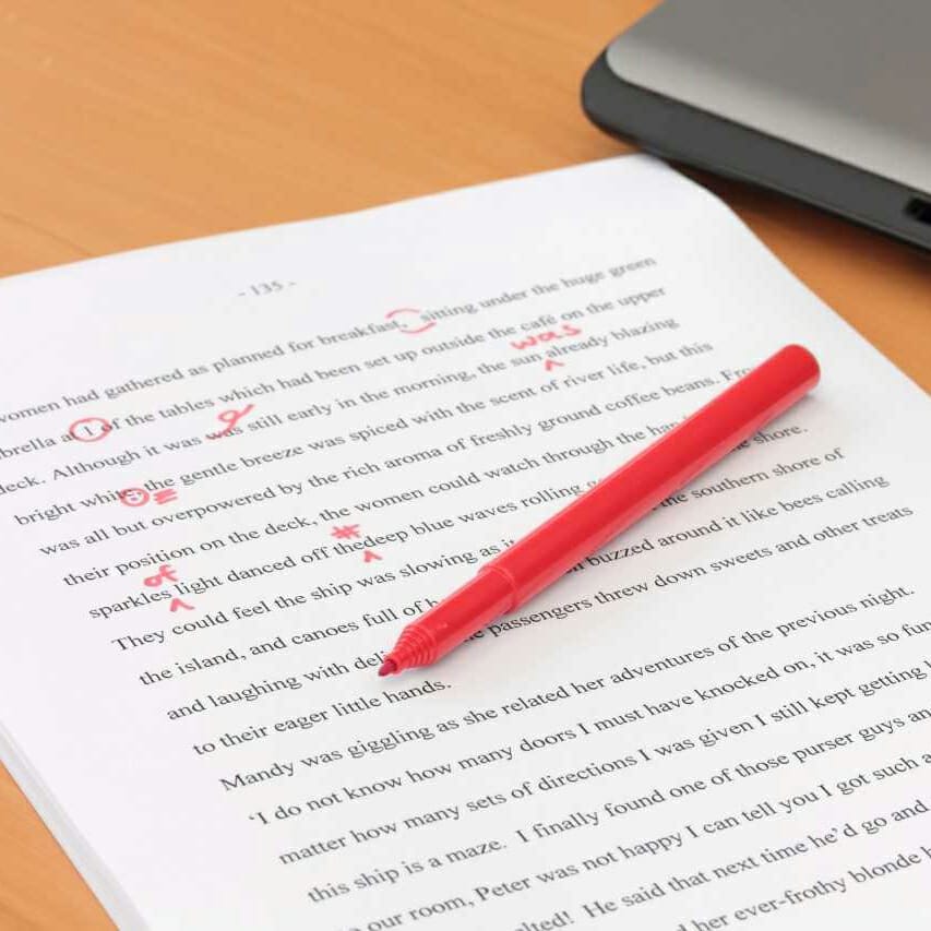 Pen and paper with red corrections